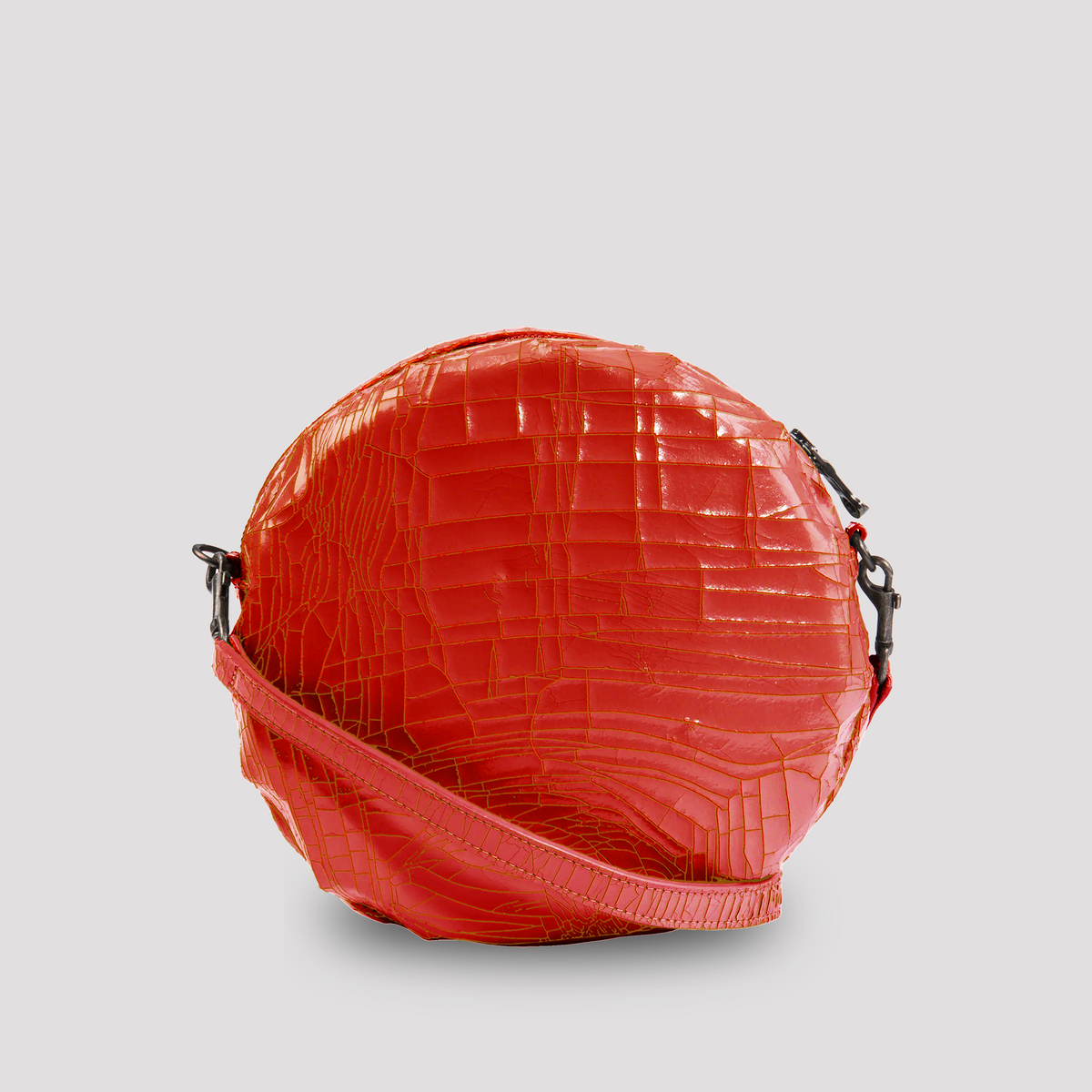 Red baby macaron from Marc Marmel, showcasing a delicate, colorful French pastry with smooth, shiny red shell and creamy filling.
