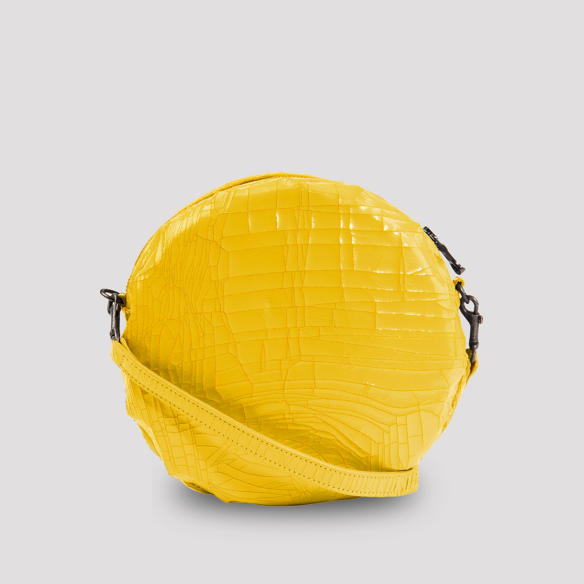 Bright yellow Marc Marmel Baby Macaron cookie on a white background, showcasing its smooth, rounded shape and delicate texture.